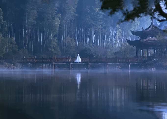 Person in White Robe on Bridge