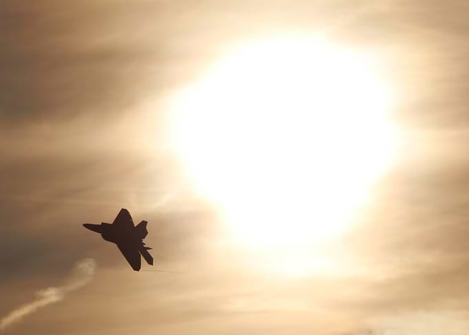 F-22 Raptor Silhouette Against Sun