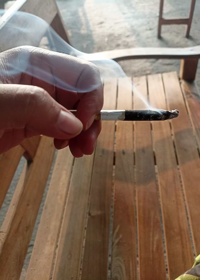 Hand holding a smoking cigarette