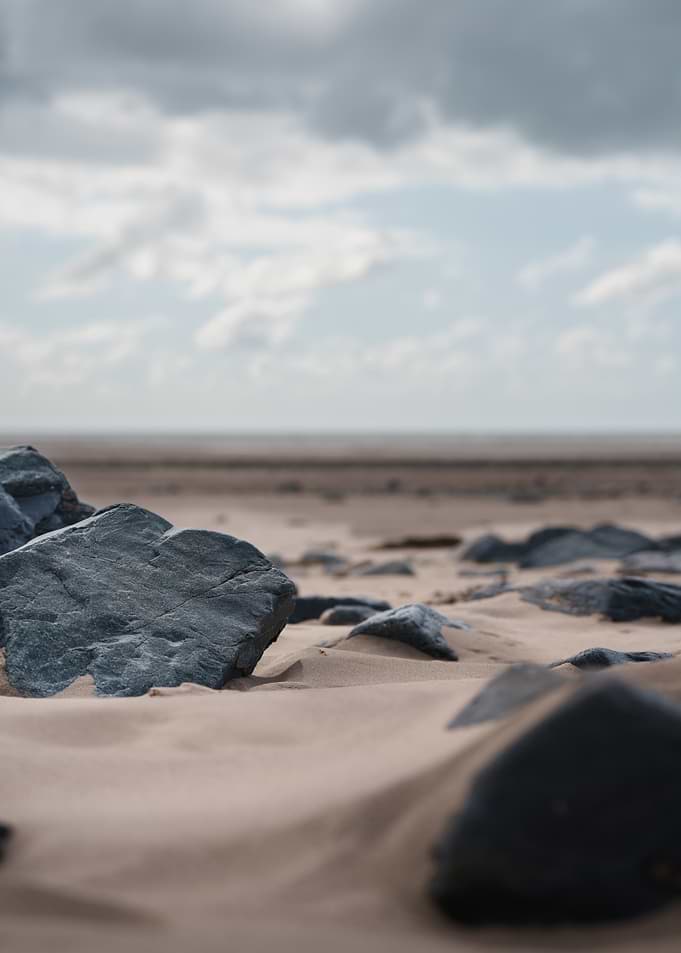 Dark Rocks on Sandy Beach