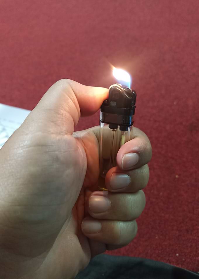 Hand Holding a Lit Lighter