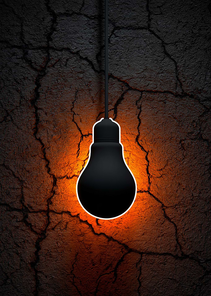Glowing Black Lightbulb on Cracked Wall