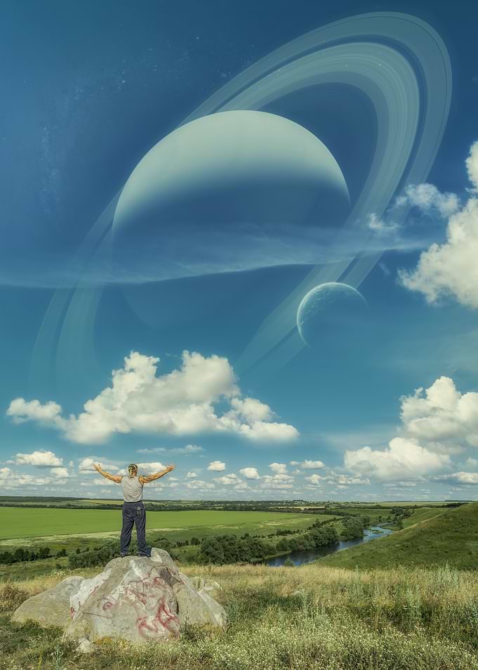 Man Standing on Rock Under Planets