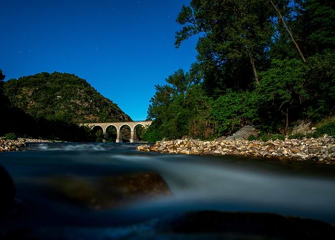 Stone Bridge Over River at Night