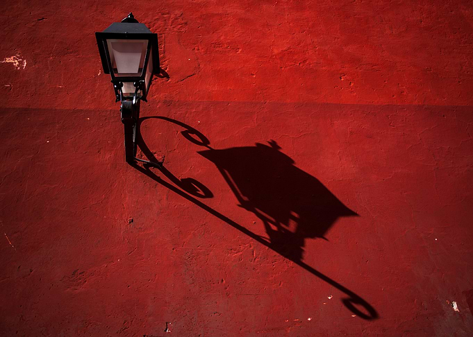 Street Lamp Casting Shadow on Red Wall