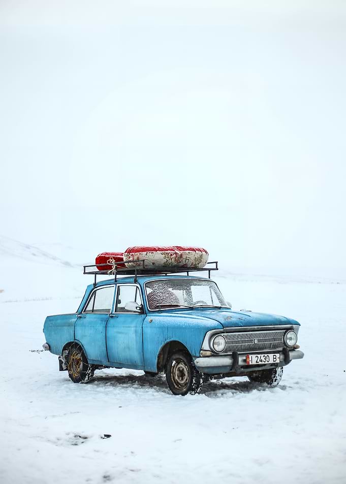 Vintage Blue Car in Snowy Landscape