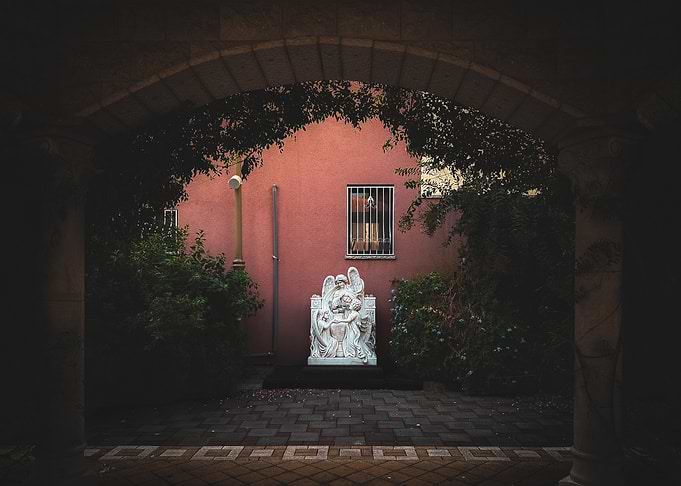 Angel Statue in Courtyard Archway