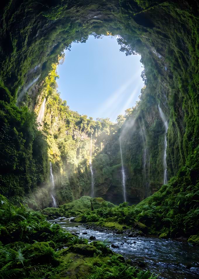 Sunlit Waterfall Inside Lush Tropical Cave