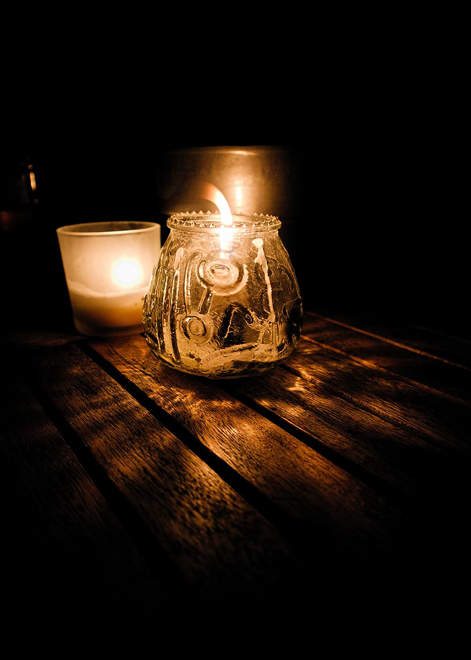 Two Lit Candles on Wooden Table