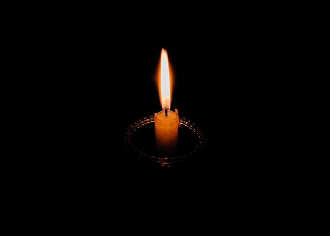 Single Lit Candle in Darkness