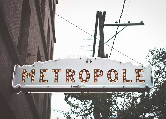 Vancouver, Canada | Vintage retro neon sign Metropole with illuminated letters and urban landscape light bulbs