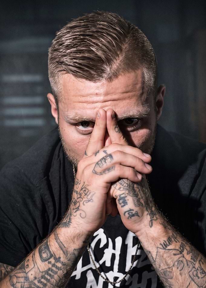 Tattooed Man Posing with Hands Together