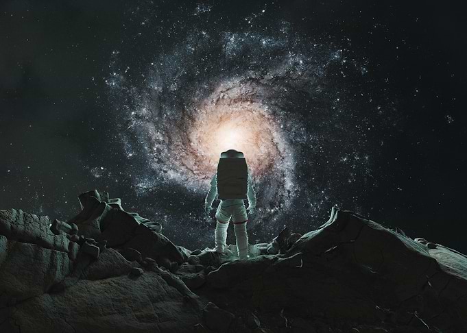 Astronaut Standing Before a Spiral Galaxy