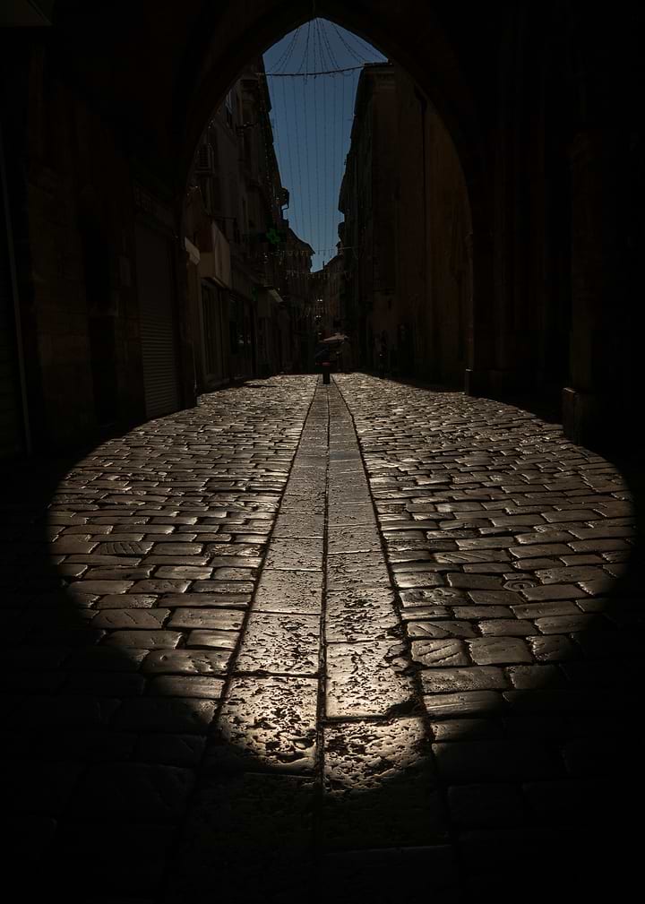 Cobblestone Street Through Stone Archway