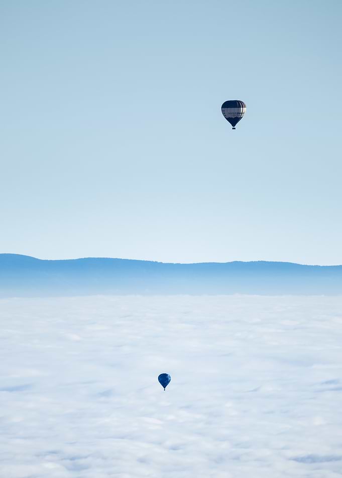 Two Hot Air Balloons Above Clouds