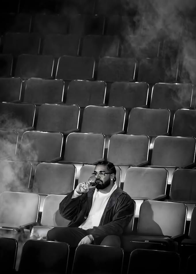 Drake drinking wine in empty theater