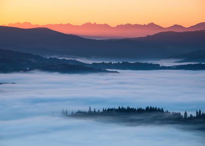 Sunrise in the mountains above a sea of ​​clouds; a view of the Tatra Mountains from Ochodzita
