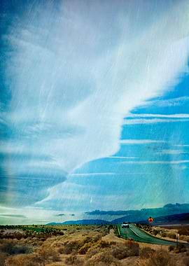 A lone pickup truck on an empty desert road is over-sha ...