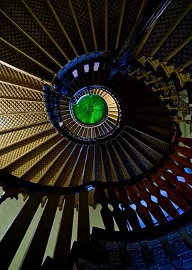 An old wooden spiral staircase with green glass ceiling ...