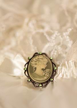 Green Victorian cameo upon a white satin and lace negli ...