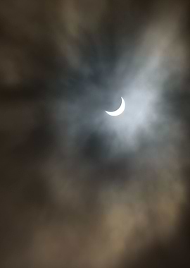 Partial solar eclipse with clouds, the moon passes betw ...