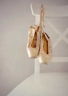 a pair of ballet shoes on a white chair