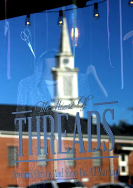 Photo of a reflection of a church in the window of a bu ...