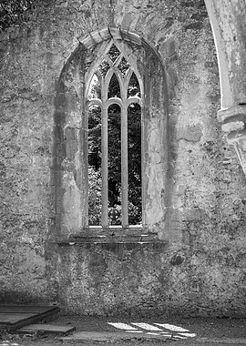 An old abbey window. With shadow and celtic cross.