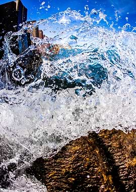 A wave crashes on a rock