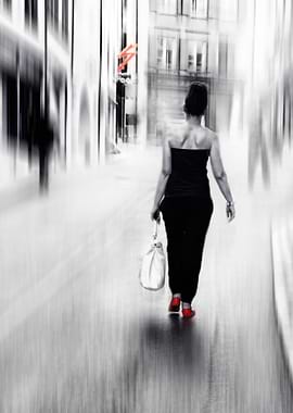 a beautiful woman walking on a street in red shoes
