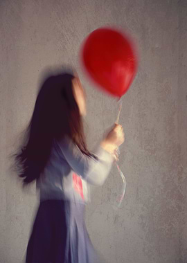 A blur girl holding a red ballon.