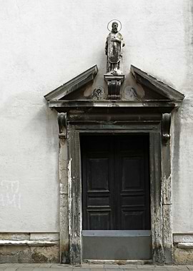 A religious statue sits atop an embellished doorway in ...