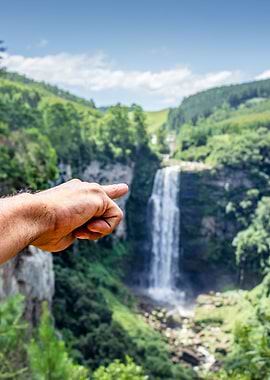 Hand pointing at waterfall