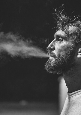 Bearded man smoke exhale