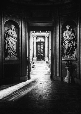 Mafra, Portugal. Basilica of Mafra. Black and White photo of a dimly lit chapel and corridor with Saint Mary Salome and Saint Barbara Statues. 18th century Italian religious baroque statues. Palacio Nacional de Mafra National Palace.