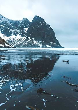 Snowy Mountain Reflection in rough Norwegian weather at Kvalvika Beach