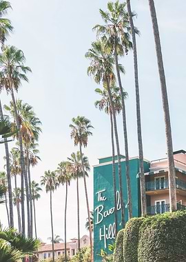 Los Angeles, USA I Green midcentury architecture of Beverly Hills Hotel under LA sun and palm trees with retro vintage summer pastel aesthetic of a film camera just like in the 1960s Hollywood movies