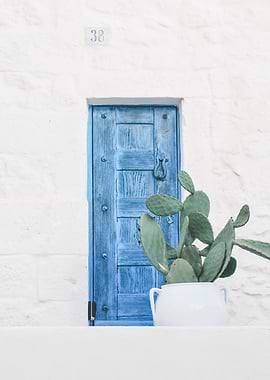 Puglia, Italy I The minimalist blue door and boho cactus in authentic Mediterranean Ostuni village on a geometric white wall with a retro vintage aesthetic during the Italian Indian pastel summer