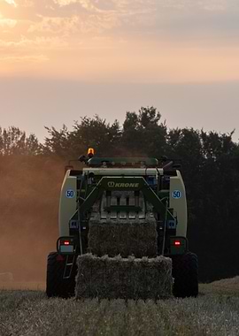 Strohpressen im Sonnenuntergang