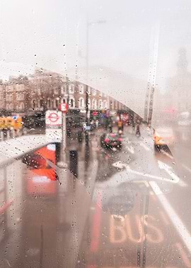 London, England I View of a rainy street through the fogged window of a legendary red London bus capturing nostalgic atmosphere and vibrant colors of the city in the rain with grey moody aesthetic