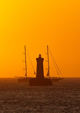 Lighthouse and Sailboats at Sunset