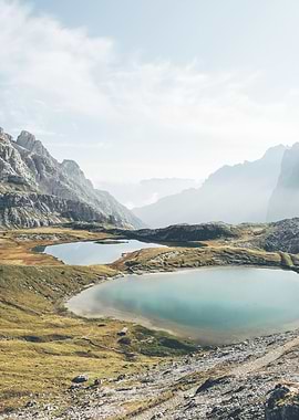 Dolomites, Italy I Alps mountain scenery and crystal clear water lakes in Tre Cime di Lavaredo in the morning sunlight in a rustic authentic wilderness with a pastel italian aesthetic