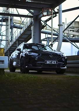 Sleek Black Car Under Industrial Structure