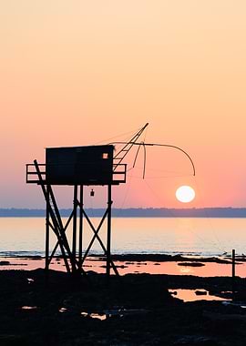 Silhouette of fishing hut at sunset