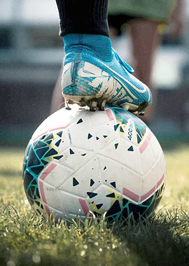 Soccer ball and cleat on grass