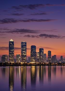 City skyline at dusk reflected in water