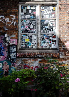 Sticker-covered window on brick wall