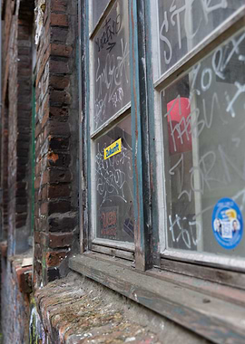Graffiti-covered window on brick building