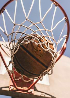 Basketball in Net Against Blue Sky