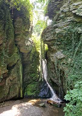 Waterfall in a rocky, green canyon